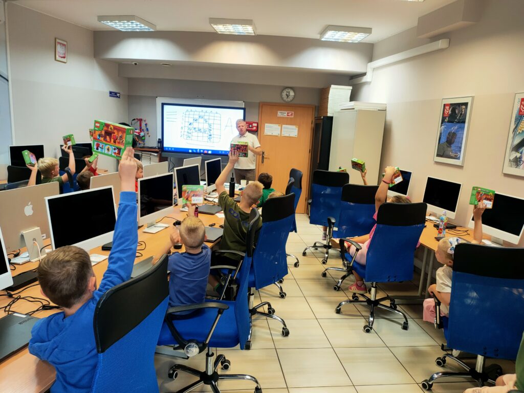 dzieci podnoszące ręce w sali warsztatowej